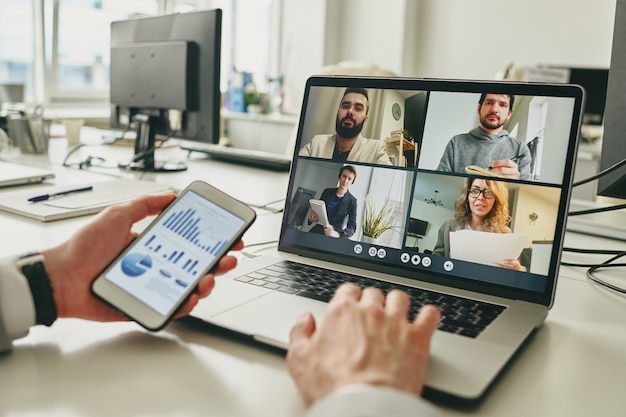 Close-up of businessman working in empty office and using smartphone