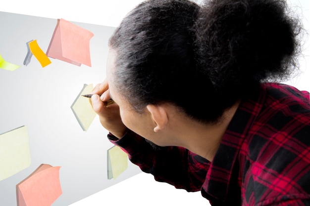 Close-up of businessman writing on adhesive notes against white background