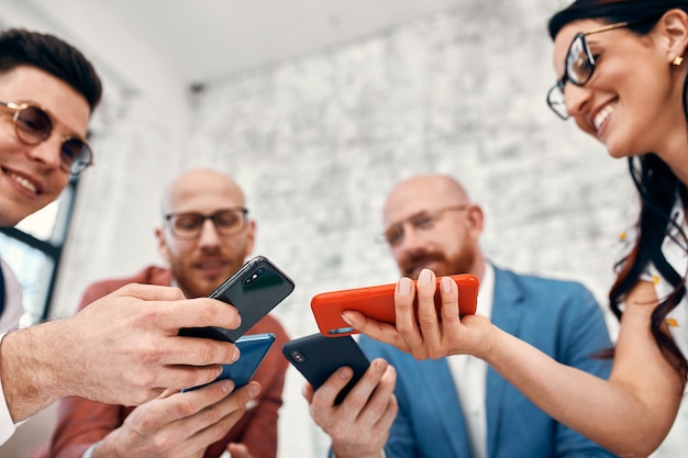 Close up of businessmen and businesswomen using smart phone, business concept.