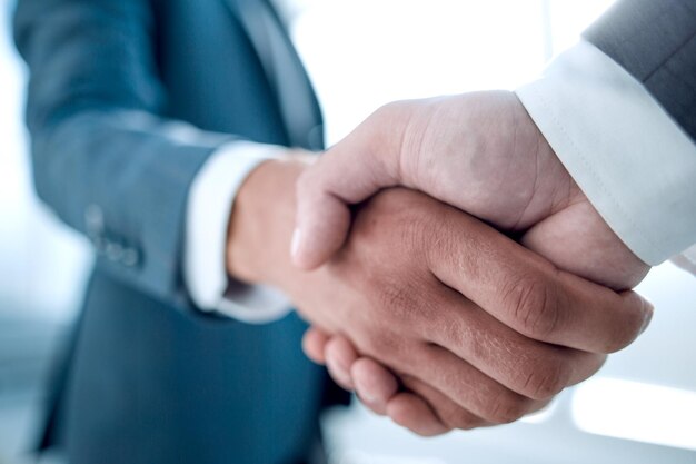 Close up of businessmen shaking hands business success ideas concept