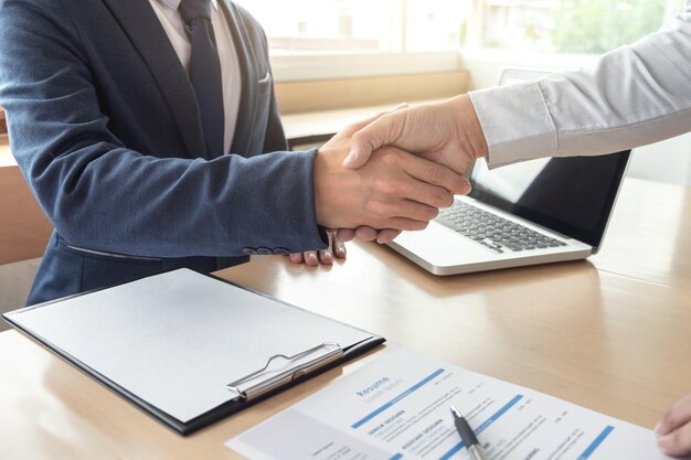 Close-up of businessmen shaking hands in office