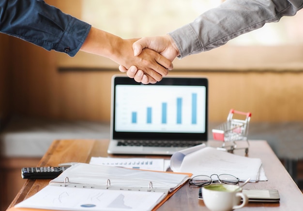 Photo close-up of businessmen shaking hands on table at office