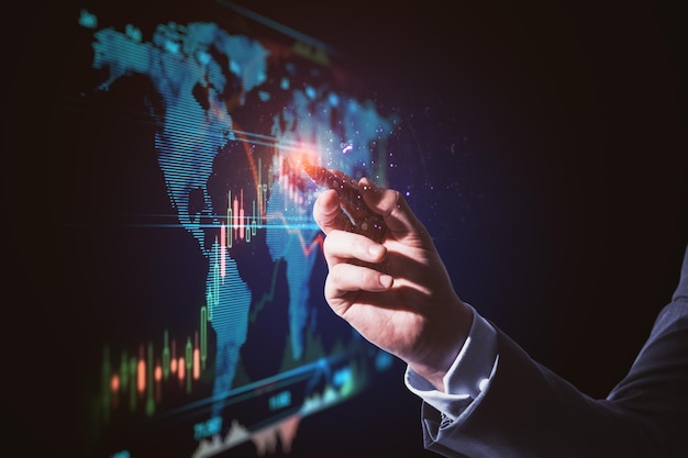 close up of businessperson hand pointing at abstract glowing blue business forex chart and map interface on dark background trade finance analysis growth technology and innovation concept