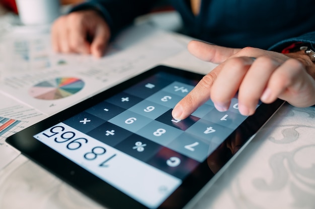 Close-up Of A Businessperson's Hand Analyzing Bill On Digital Tablet Over Desk, 