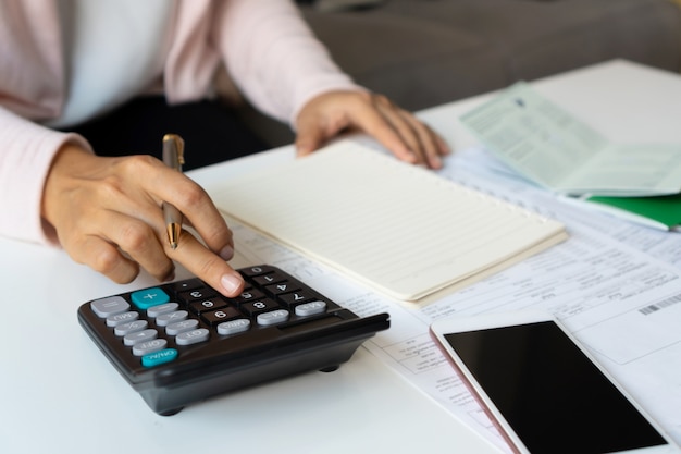 Close up of Businesswoman Calculating monthy expense at her desk. Home saving concept. Financial and Installment payment concept.