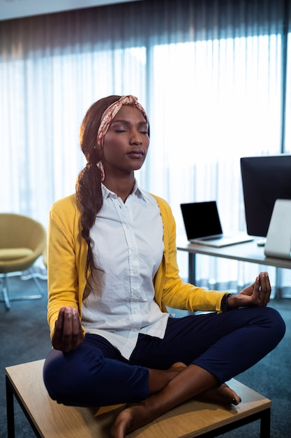 Close up of businesswoman doing yoga