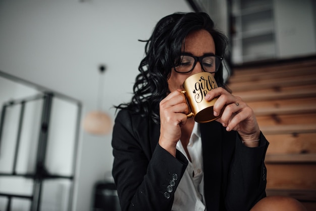 Foto close-up di una donna d'affari che beve caffè seduta a casa