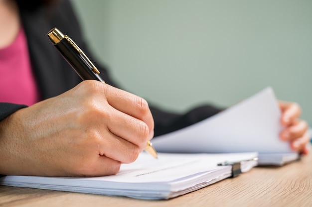 Close Up businesswoman hand sign contract document at business desk in a business office