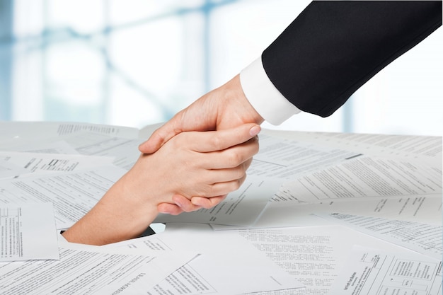 Close up of businesswoman hand in stack of papers