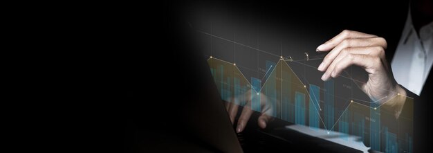 Close-up businesswoman hand using a laptop touchpad to open a financial report, a graphic showing financial and numerical growth data. The concept of financial management to grow and be profitable.