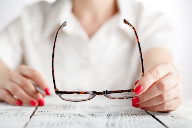 Close-up of businesswoman hands holding eyeglasses