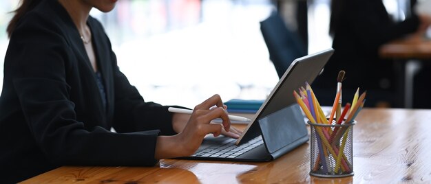 Close up on businesswoman hands typing on wireless keyboard of digital tablet