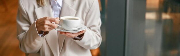 Close up of businesswoman having coffee break time during working day in cafe