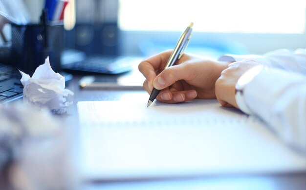 Close-up of Businesswoman makes a note at business document