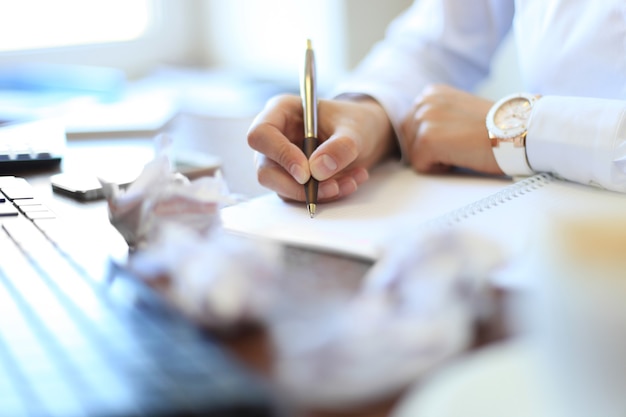 Close-up of Businesswoman makes a note at business document