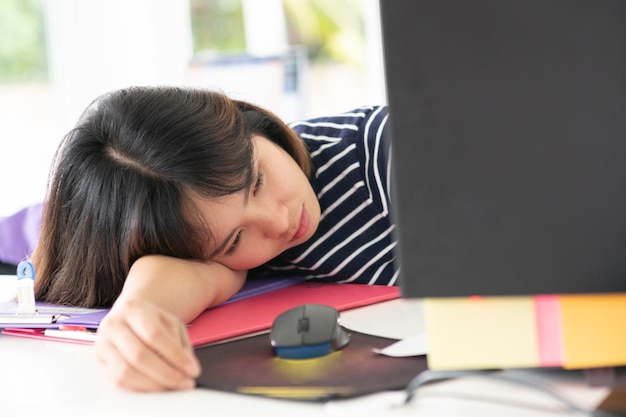 Close-up of businesswoman resting at desk in office