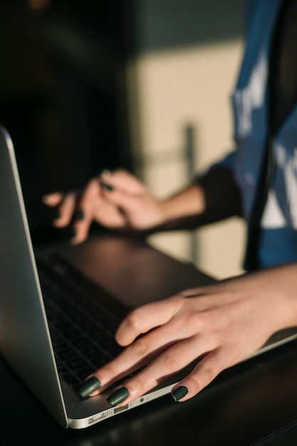 Foto primo piano della mano di una donna d'affari utilizzando il computer portatile