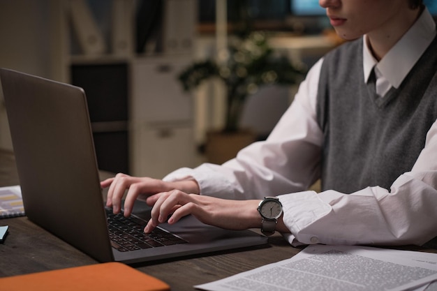 Primo piano di una donna d'affari che digita sul portatile mentre fa il suo lavoro online sul posto di lavoro in ufficio