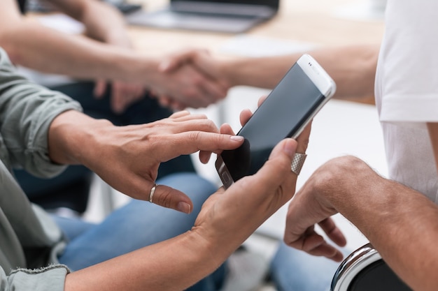 Photo close up. businesswoman uses a smartphone sitting in the office. people and technology