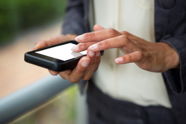 Close-up of businesswoman using mobile phone at conference centre