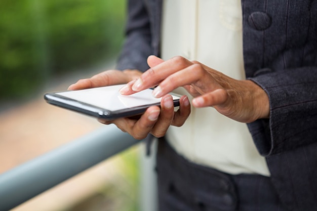 Close-up of businesswoman using mobile phone at conference centre