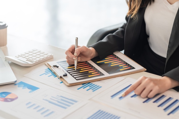 Close-up of businesswoman working hand pointing  graph at the office.