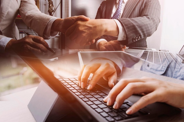 Close up of businesswoman working with smart phone and laptop and digital tablet computer in modern office with virtual icon diagram