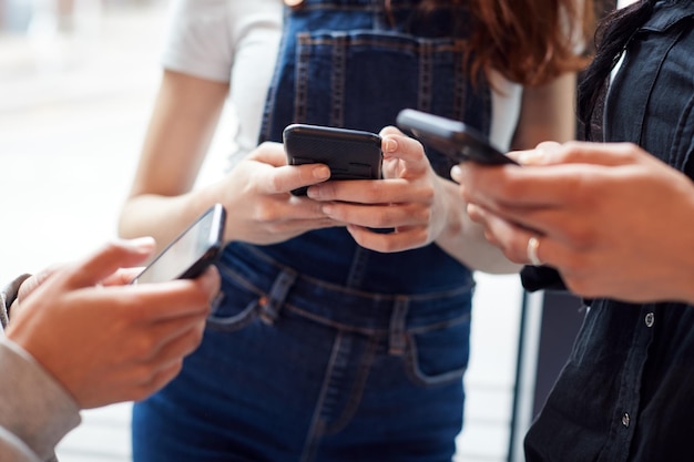 Photo close up of businesswomen using mobile phones in modern office