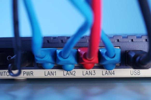 Close-up of cables and router against blue background