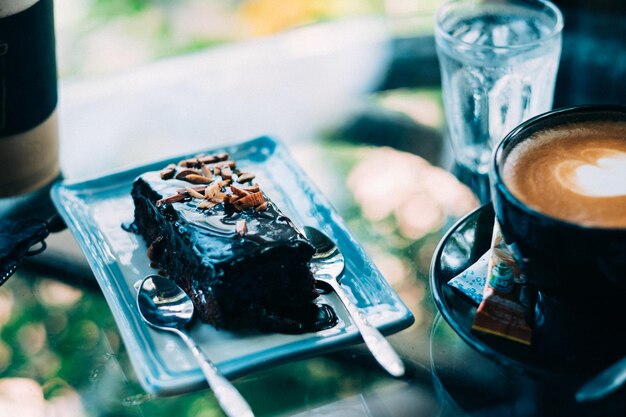 Foto close-up di una torta con una tazza di caffè in un piatto sul tavolo