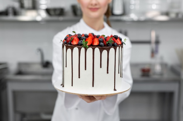 Close-up of a cake in the hands of a pastry chef.