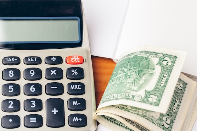 Close up of a calculator and coins on a business background