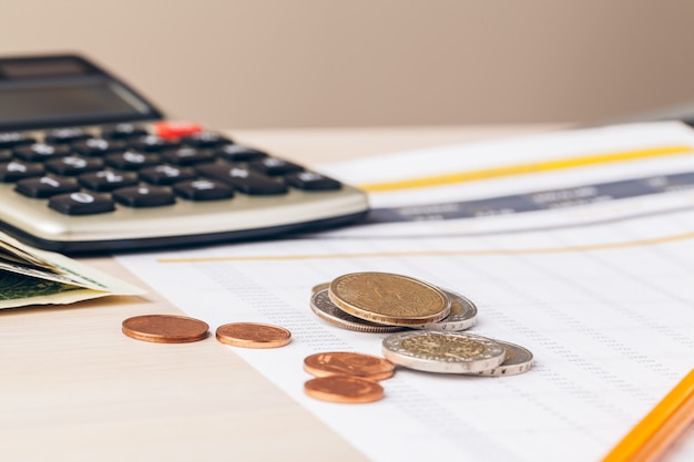 Close up of a calculator and coins on a business 