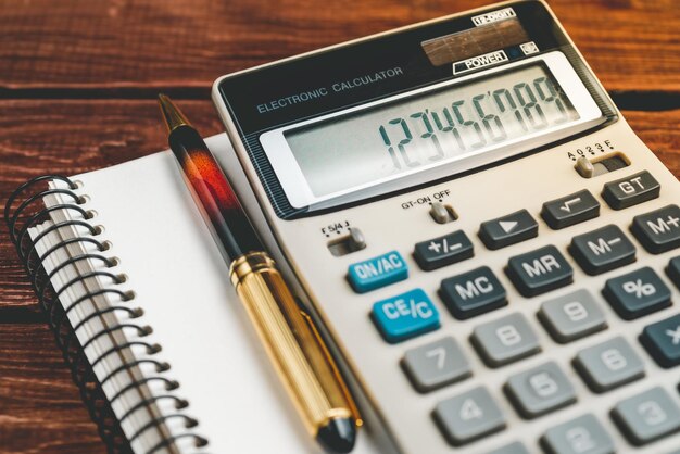 close up of calculator and pen on notebook