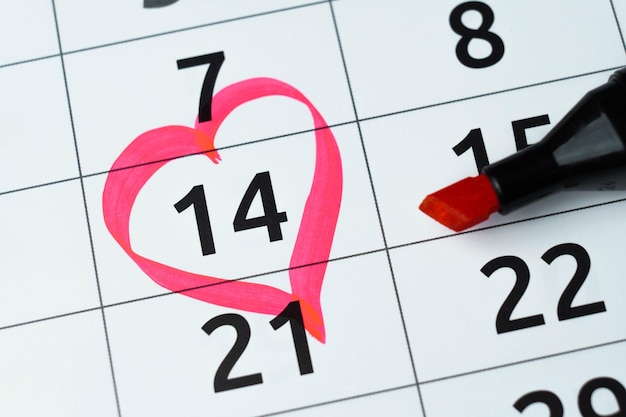 Close up calendar with 14 February date Valentines day with red heart shape marker and gift box