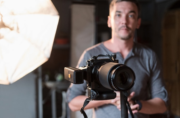 Close-up of the camera on the background of the photographer and lighting equipment