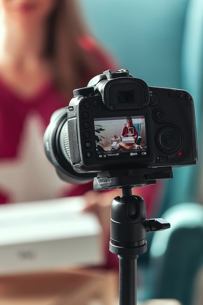 Close-up camera screen, woman blogger makes video of unpacking