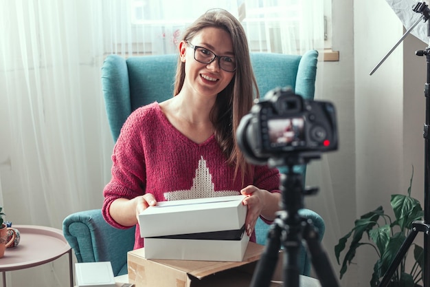 Close-up camerascherm vrouw blogger maakt video van thuis uitpakken van gadgets