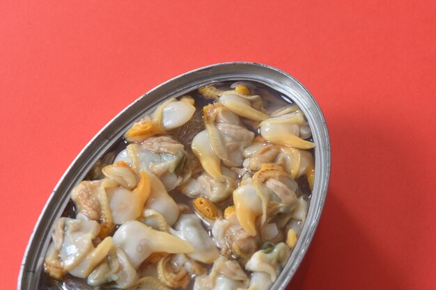 Close up of a can of pickled mussel on red background