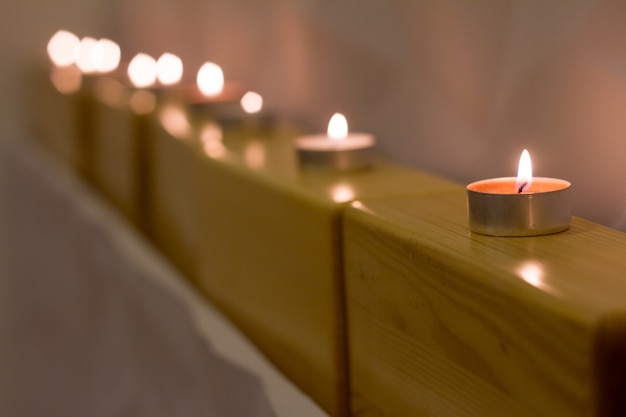 Close-up candles are standing on wooden blocks for yoga, atmosphere for meditation