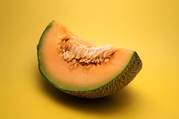 Close-up of cantaloupe slice on yellow background