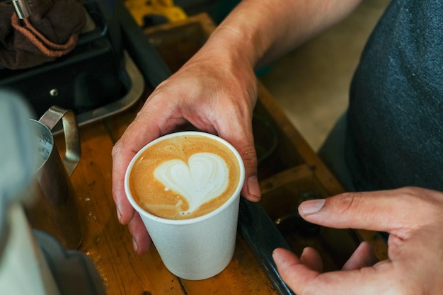 Photo close up cappuccino with latte art on wood table