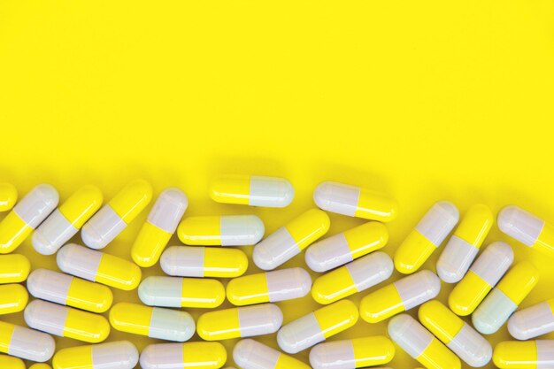 Photo close-up of capsules over yellow background