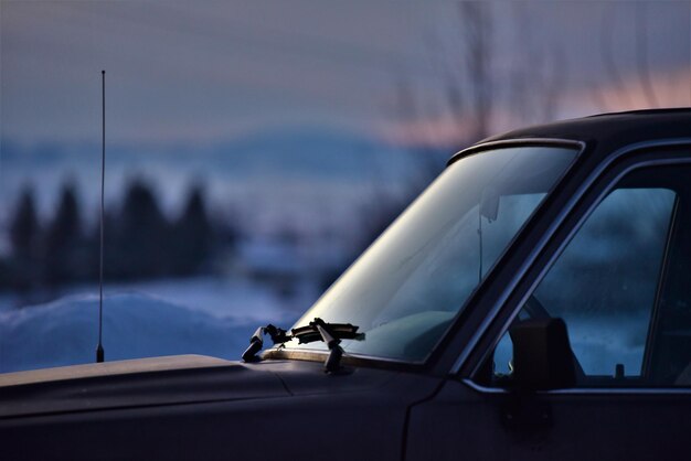 Close-up of car against sky at sunset