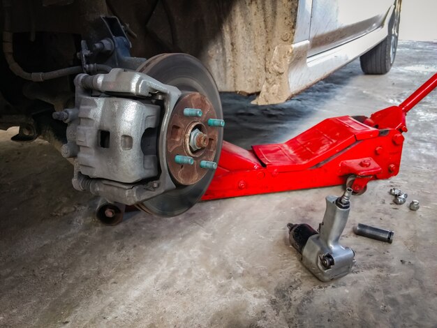 Close up car in garage fix wheel with equipment.