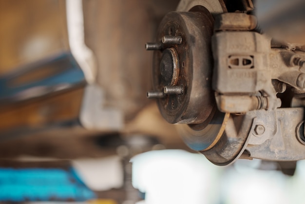 Крупным планом Автомеханик заменяет шину на колесе в мастерской по ремонту автомобилей.