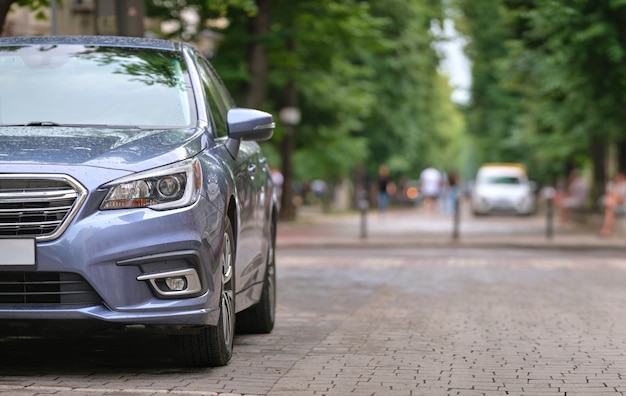 Photo close up of a car parked on city street side.