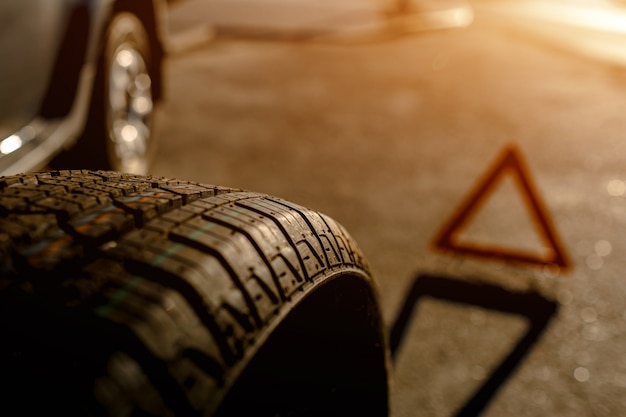 Close-up of a car tire. The driver should replace the old wheel with a spare.