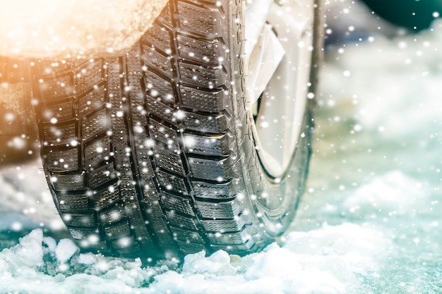 Close-up of car wheel in winter tire on snowy road