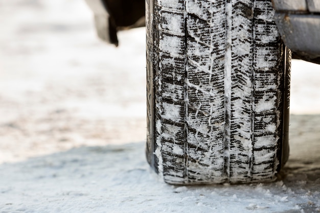 Close up of car wheels rubber tires in deep winter snow road